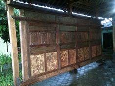 an old wooden garage door in the middle of a building with tile flooring and walls