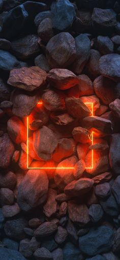 an orange neon frame on some rocks