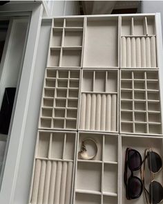 several pairs of sunglasses are sitting in a white box with dividers on the floor