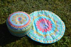 two round pillows sitting on top of a grass covered field