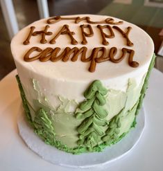 a green and white cake with the words happy camper written on it's side