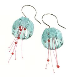 two pairs of earrings with red beads hanging from the end of each earring, on a white background