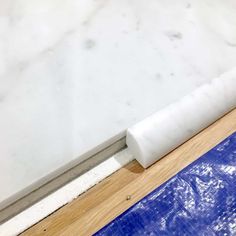 a roll of plastic sitting on top of a wooden floor next to a blue tarp