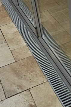 a cat is sitting on the floor in front of a glass window with grates