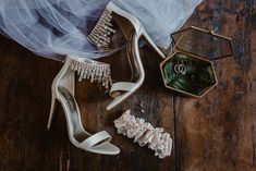 wedding shoes and jewelry on a wooden floor