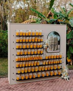 there is a large display with many cups on it in front of some trees and bushes