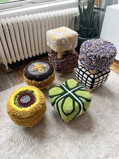 four decorative stools are sitting on the floor next to a radiator and window