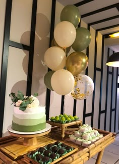 a table topped with cake and balloons on top of it