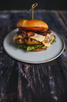 a bacon and apple sandwich on a plate with a toothpick in the middle