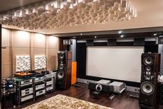 a living room with speakers and a large screen