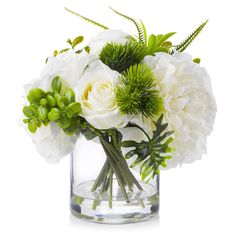 a glass vase filled with white flowers and greenery on top of a white surface