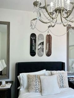 a bedroom with a bed, chandelier and two skateboards on the wall