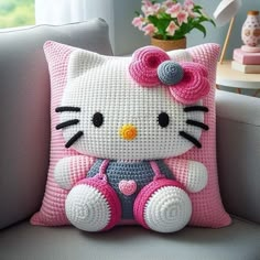 a crocheted hello kitty pillow sitting on a couch