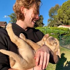 a man holding a puppy in his arms