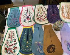 many different types of embroidered ties on a table