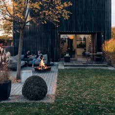 two people sitting around a fire pit on a patio