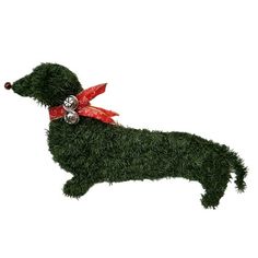 a dog made out of grass with a bell on its neck