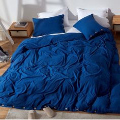 a bed with blue sheets and white pillows