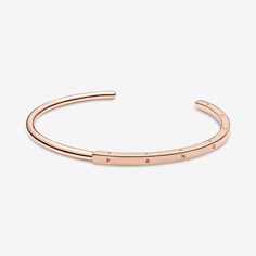 Streamline your look with the Pandora Signature I-D Bangle. With a half-squared, half-rounded profile, this 14k rose gold-plated bangle is hand-finished. The round polished profile transitions to a larger squared profile in the middle, which features the Pandora logo on its three outer sides. Each end of the bangle includes the Pandora Crown O monogram. The bangle is precisely sized for optimal performance and fit and is not designed to be flexed and twisted when put on and removed. - Pandora Signature I-D Open Bangle - 14k Rose gold-plated unique metal blend - Sz. 6.3 in Rose Gold Polished Bangle, Luxury Timeless Rose Gold Bangle, Pandora Bracelet Pink Gold, Pandora Rose Gold And Silver Bracelet, Pandora Bangle Bracelet Rose Gold, O Monogram, Pandora Logo, Open Bangle, Rose Gold Plates