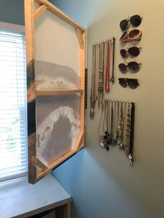 a wall mounted jewelry rack with sunglasses on it