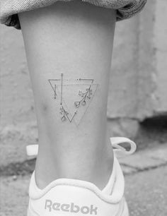 a woman's foot with a small triangle tattoo on the side of her leg