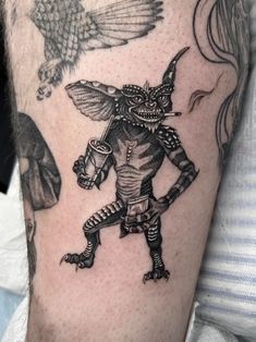 a man with a tattoo on his leg and an owl flying above him, in front of