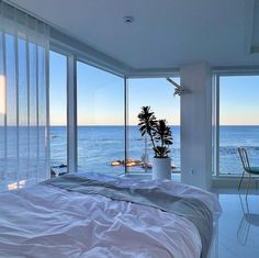 a bedroom with large windows overlooking the ocean