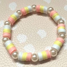 a close up of a beaded bracelet on a table with polka dot fabric material