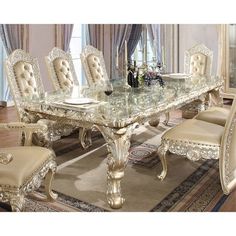 an ornate dining room table and chairs with glass top