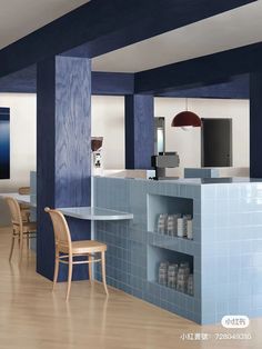 an empty kitchen with blue tiles and wooden chairs in front of the counter top area