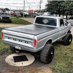 the truck is parked on the side of the road in front of other cars and trucks