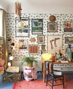 a room filled with lots of pictures on the wall next to a desk and chair