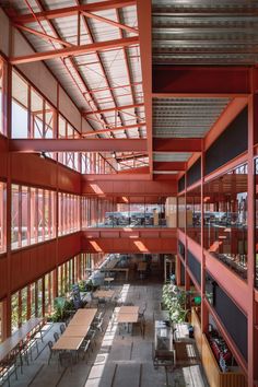 the inside of a building with tables and chairs on each floor, windows open to let in light