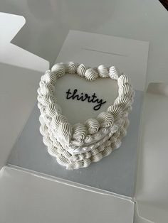 a heart shaped cake with the word thirty written on it