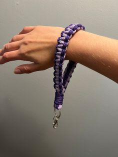 a woman's arm with two bracelets on it and a keychain hanging from the wrist