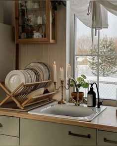 a kitchen sink filled with dishes next to a window