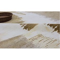 a basket sitting on top of a rug next to a white and brown area rug