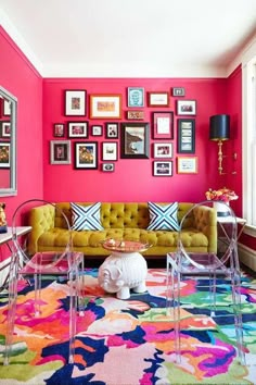 a living room with pink walls and colorful rugs on the floor in front of it