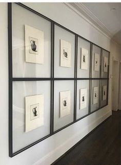 a wall with framed pictures on it and wood flooring in front of the wall