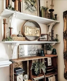 an old wooden shelf with various items on it and a clock hanging above the shelves