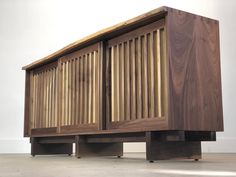 a large wooden cabinet sitting on top of a hard wood floor next to a white wall