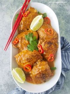 a white plate topped with meat covered in sauce and garnished with cilantro