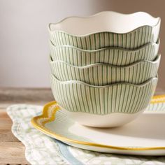 a stack of bowls sitting on top of a white plate next to a green and yellow napkin