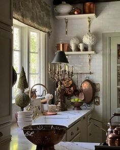 a kitchen filled with lots of clutter and cooking utensils on top of a counter