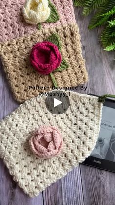 two crocheted purses sitting next to each other on a wooden table with flowers