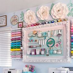 there are many crafting supplies on the wall above the sewing machine and washer