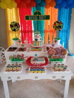 a table topped with lots of cakes and cupcakes