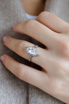 a woman's hand with a diamond ring on it