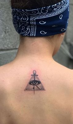 the back of a woman's neck with an all seeing eye tattoo