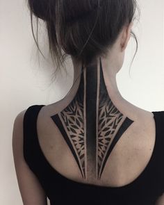 the back of a woman's neck with an intricate tattoo